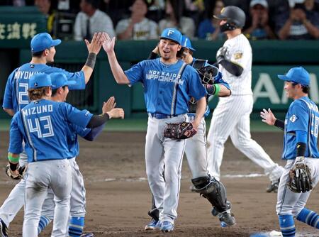 　完封勝利を飾りナインとタッチを交わす伊藤