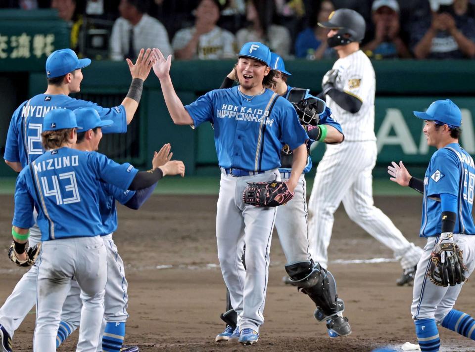 　完封勝利を飾りナインとタッチを交わす伊藤