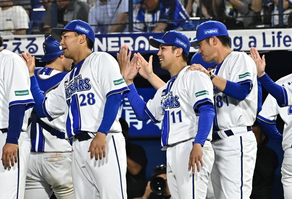 並んでナインとハイタッチを交わす東と相川監督（撮影・持木克友）