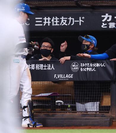 ４回、同点犠飛を放った野村（左）に「あと少し」のポーズで迎える新庄監督（右）＝撮影・中島達哉