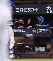 ４回、同点犠飛を放った野村（左）に「あと少し」のポーズで迎える新庄監督（右）＝撮影・中島達哉