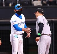 メンバー表を交換し、橋上監督代行（右）と握手を交わす新庄監督（撮影・中島達哉）