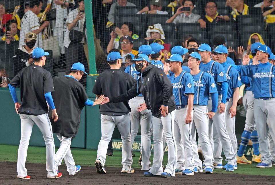 　交流戦を３連勝スタートで飾り、ナインとタッチを交わす新庄監督（中央）＝撮影・立川洋一郎