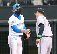 　メンバー表を交換し、橋上監督代行（右）と握手を交わす新庄監督