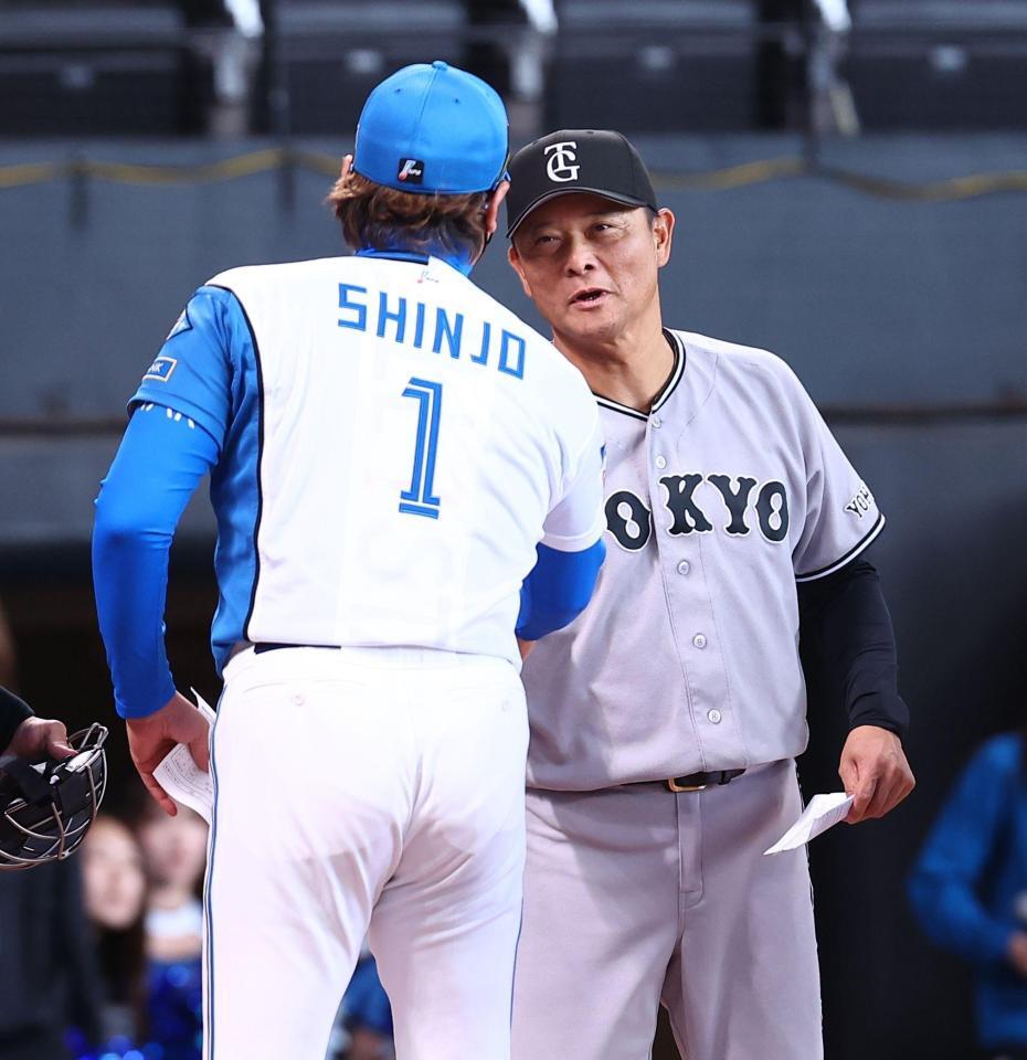 メンバー表を交換し、新庄監督（１）と握手を交わす橋上監督代行（撮影・中島達哉）