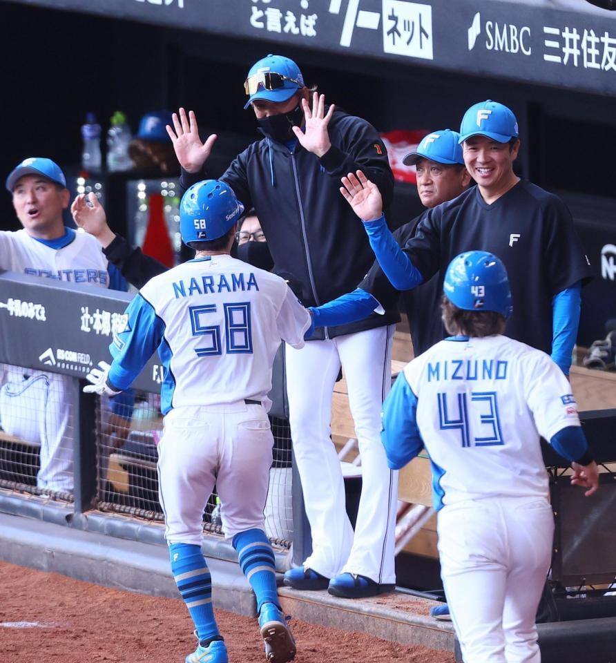３回、郡司の先制打で生還した三走・奈良（５８）、二走・水野（４３）を迎える新庄監督（中央）＝撮影・中島達哉