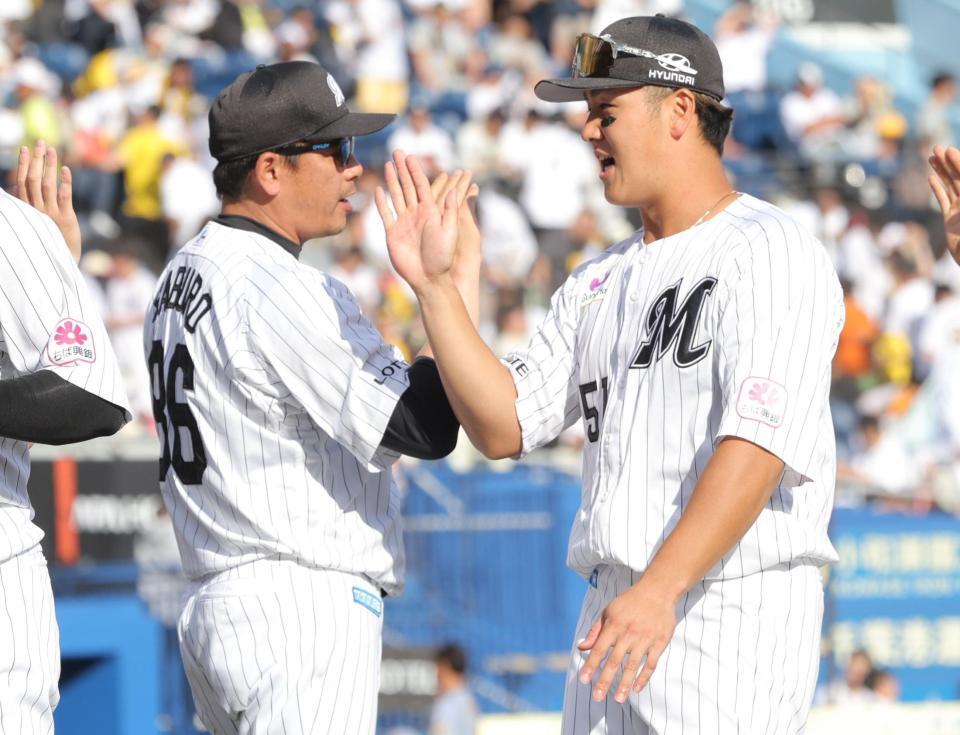 阪神に勝利し、山口（右）とタッチを交わすサブロー監督（撮影・西岡正）