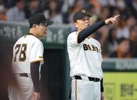 ８回、川相コーチ（左）と話して選手交代に向かう橋上監督代行（撮影・西岡正）