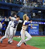 リプレイ検証の結果、アウト判定が覆りサヨナラ勝ち。決勝のホームインを決めた三森（右）は牧（中央）から歓喜のシャワーを浴びる（撮影・佐藤厚）