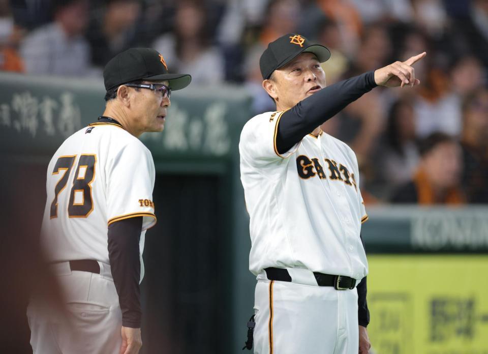 ８回、川相コーチ（左）と話して選手交代に向かう橋上監督代行（撮影・西岡正）