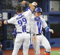 ５回、ソロを放ち、ヒュンメル（左）とタッチを交わす松尾（撮影・西岡正）