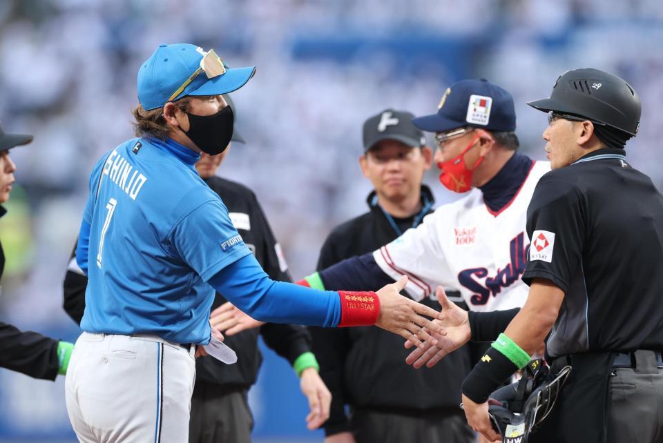 メンバー表を交換する新庄監督と池山監督（撮影・金田祐二）