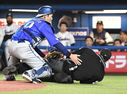 バットが直撃し、もんどりうって倒れ込む川上球審（右）＝４月
