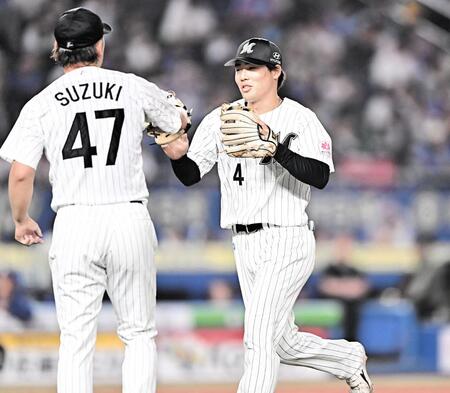 ８回、サノーを遊ゴロに打ち取った鈴木（左）とタッチを交わす友杉（撮影・開出牧）