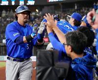 ７回、本塁打を放ちナインに迎えられる宮崎（左）