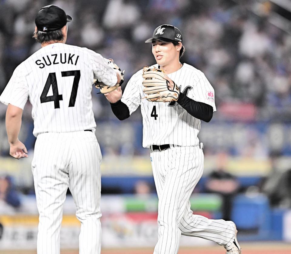 ８回、サノーを遊ゴロに打ち取った鈴木（左）とタッチを交わす友杉（撮影・開出牧）