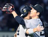 楽天に完封勝利し、捕手の大城（左）と抱き合う戸郷