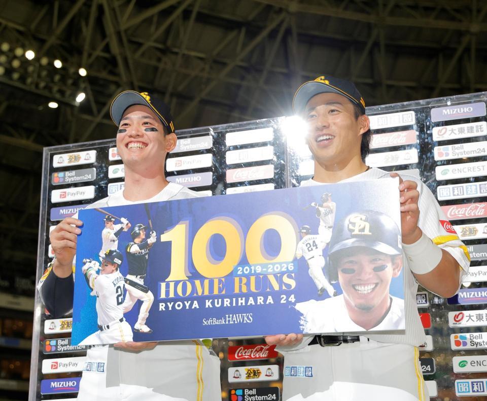 お立ち台で自身の通算１００号本塁打のボードを手に笑顔の栗原と野村（右）＝撮影・西田忠信
