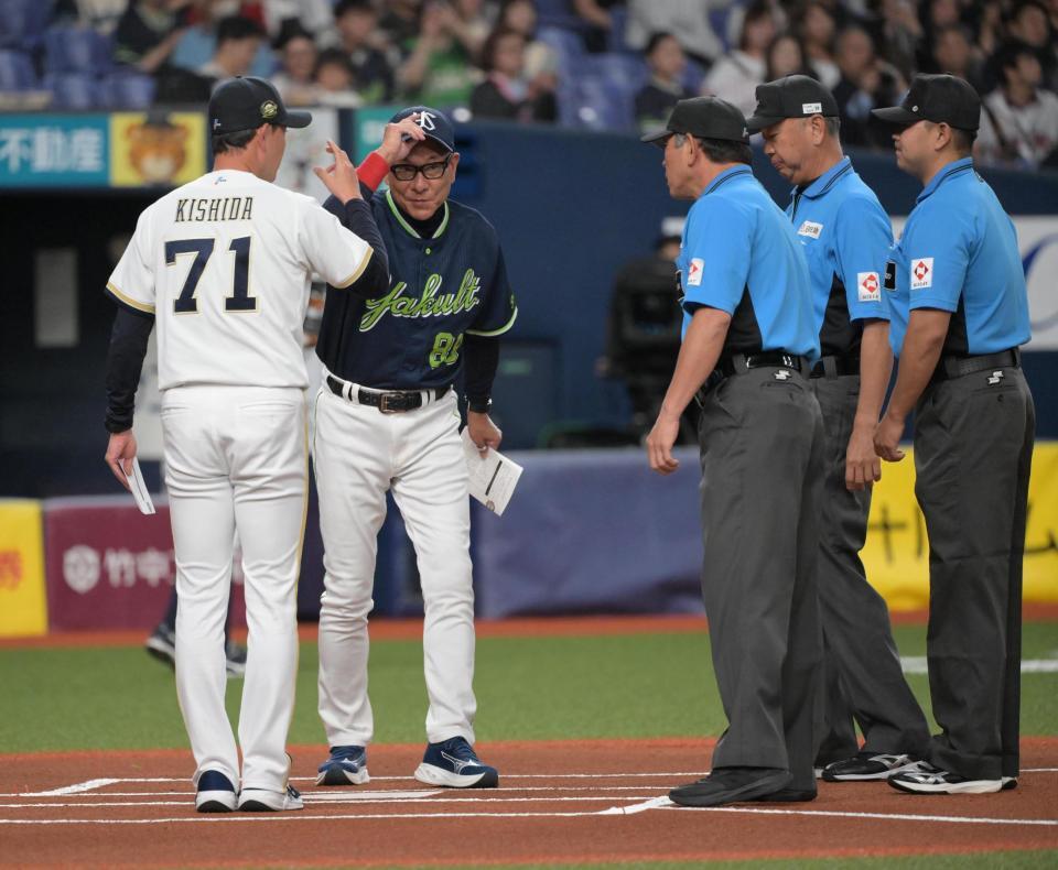 メンバー表を交換する池山、岸田両監督（撮影・金居みつよし）