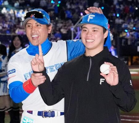 来日初勝利を挙げ、新庄監督（左）とポーズをとる孫易磊