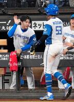 ６回、野村の先制犠飛で生還した水谷（手前）を迎える日本ハムの孫易磊