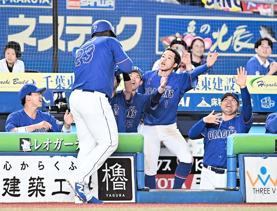 ８回、同点の左越えソロを放ちナインとタッチを交わすサノー（左手前）＝撮影・開出牧