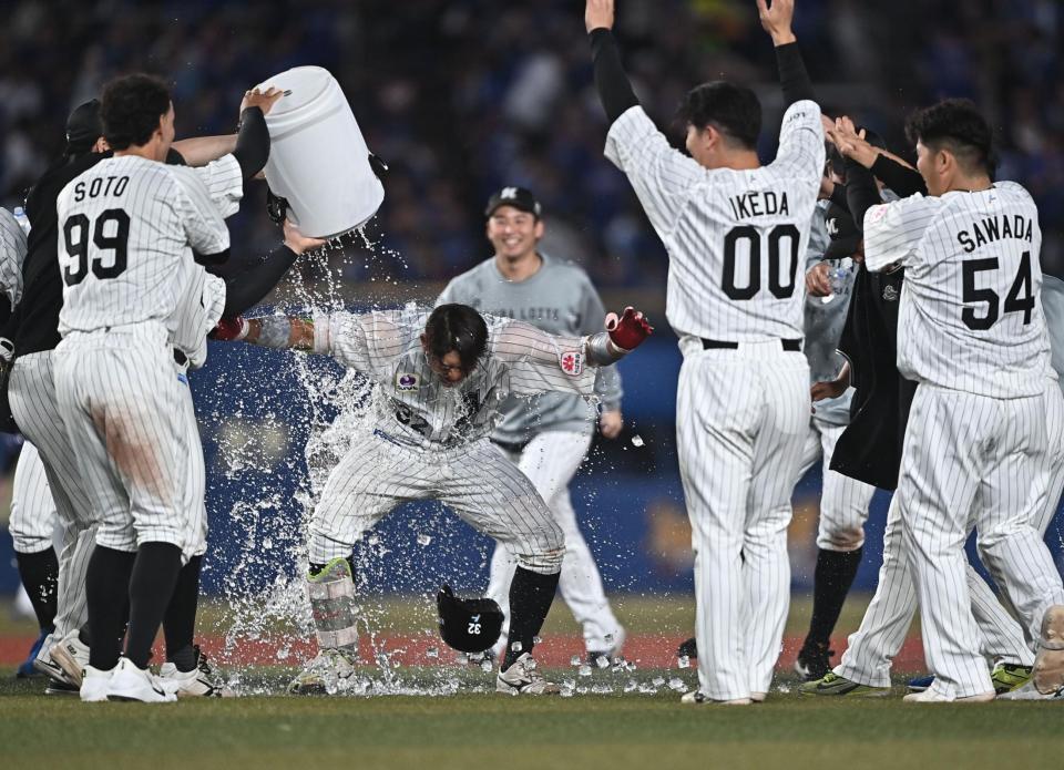 １０回、サヨナラの右前適時打を放ちナインから手洗い祝福を受ける佐藤（中央）＝撮影・開出牧