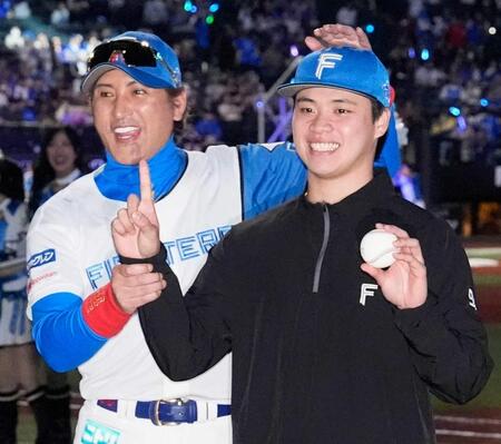 　来日初勝利を挙げ、新庄監督（左）とポーズをとる孫易磊