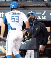 １回、マルティネスの三ゴロの間に生還した水谷（左）を迎える新庄監督