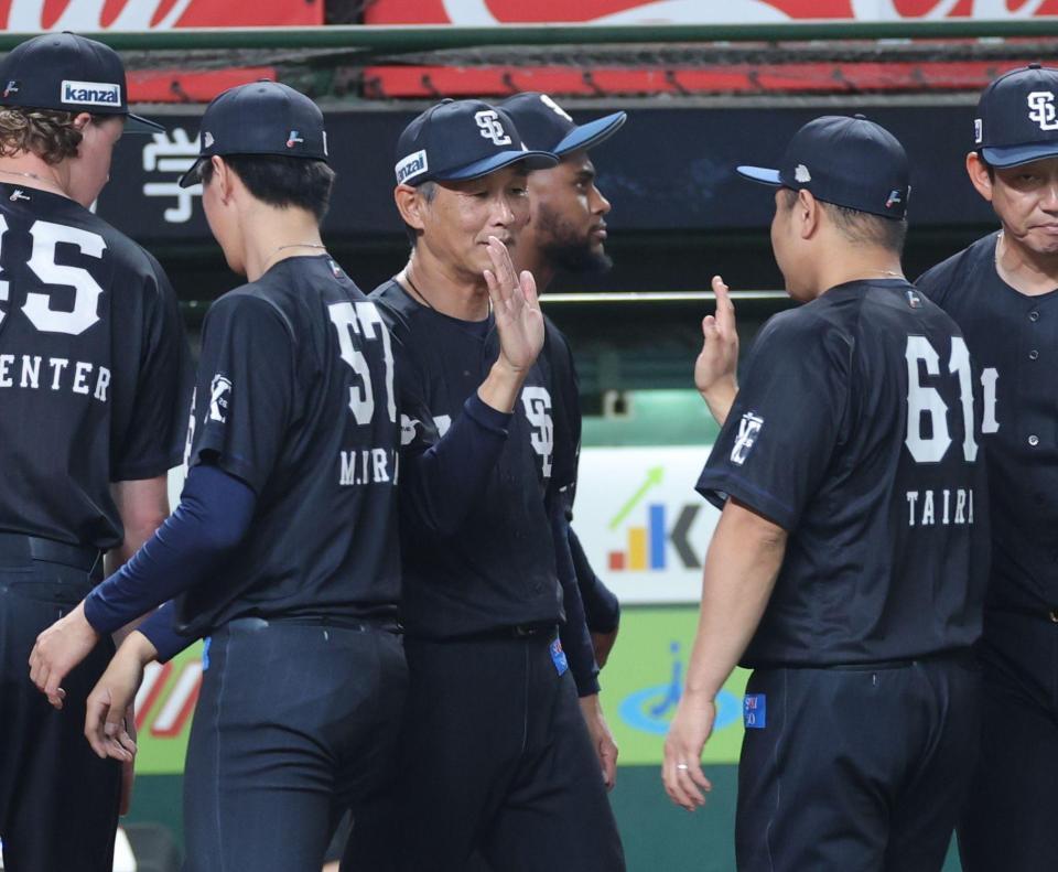 広島に３連勝し、平良（右）とタッチを交わす西口監督（撮影・西岡正）