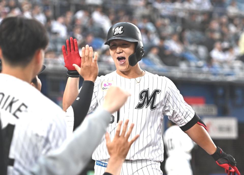 ２回、先制の中越えソロを放ちナインとタッチを交わす山口（撮影・開出牧）