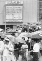 　雨の中引き揚げるファン＝１９９０年８月１０日