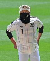 サッカー日本代表のアウェー用ユニホームを着て練習を見る新庄監督　