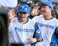 ８回裏、本塁打を放ちナインに祝福される日本ハム・田宮（左）
