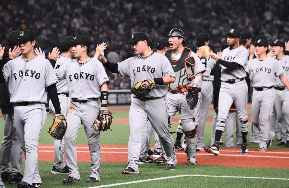 連敗をストップさせタッチをかわすリチャード（中央）ら巨人ナイン（撮影・園田高夫）