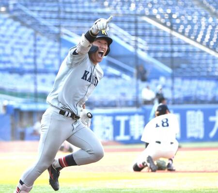 　９回、関大・山本は国学院大・藤本（右）からサヨナラ打を放ち、喜びながら一塁へ走る（撮影・佐藤厚）