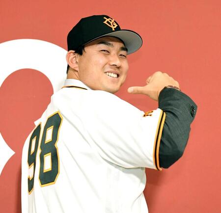 　背番号９８のユニホームに袖を通した小笠原（撮影・佐藤厚）