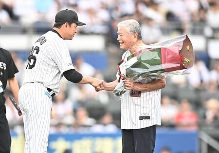 始球式を務めた元サッカー協会会長の川淵三郎氏（右）はサブロー監督から花束を受け取り握手を交わす（撮影・開出牧）