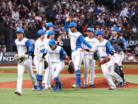 対ソフトバンク戦で今季初勝利をあげ、笑顔でタッチを交わす日本ハムナイン（撮影・中島達哉）