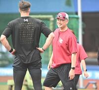 試合前の練習を行うマッカスカー（左）と談笑する吉井監督（撮影・開出牧）