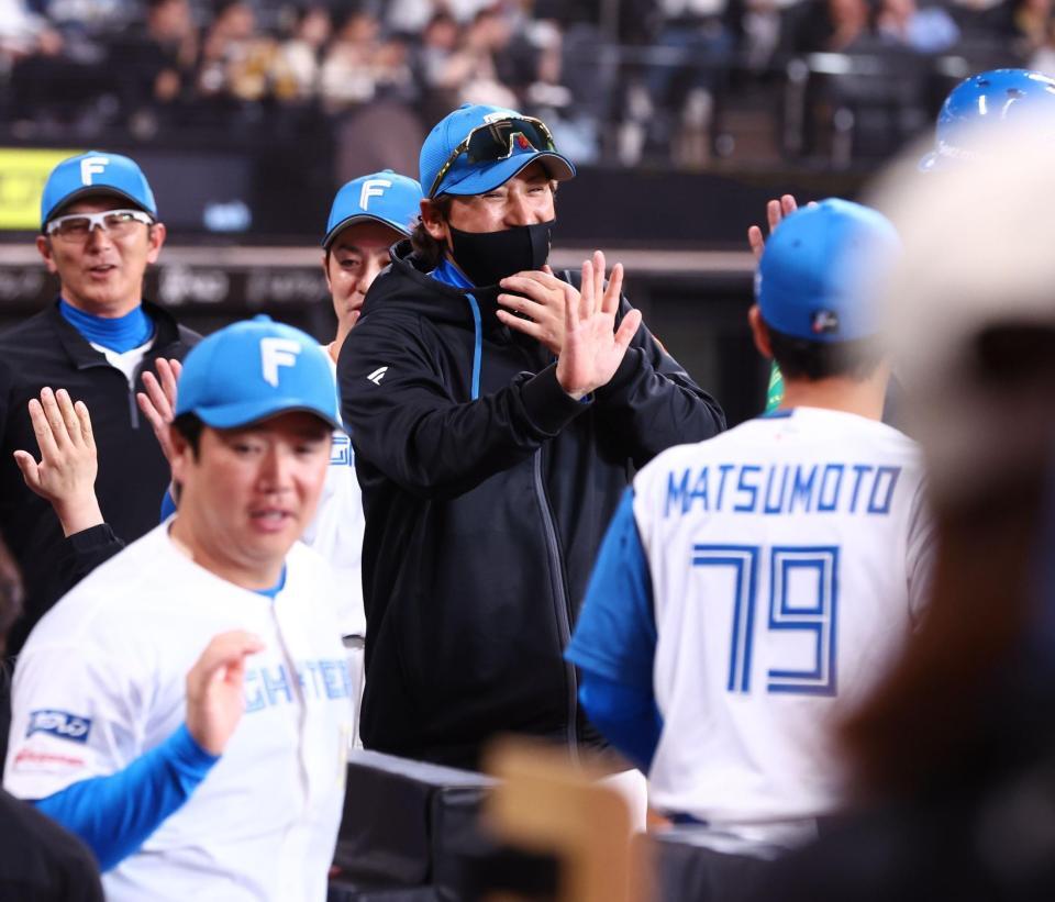 対ソフトバンク戦で今季初勝利をあげ、笑顔でタッチを交わす新庄監督（中央）＝撮影・中島達哉