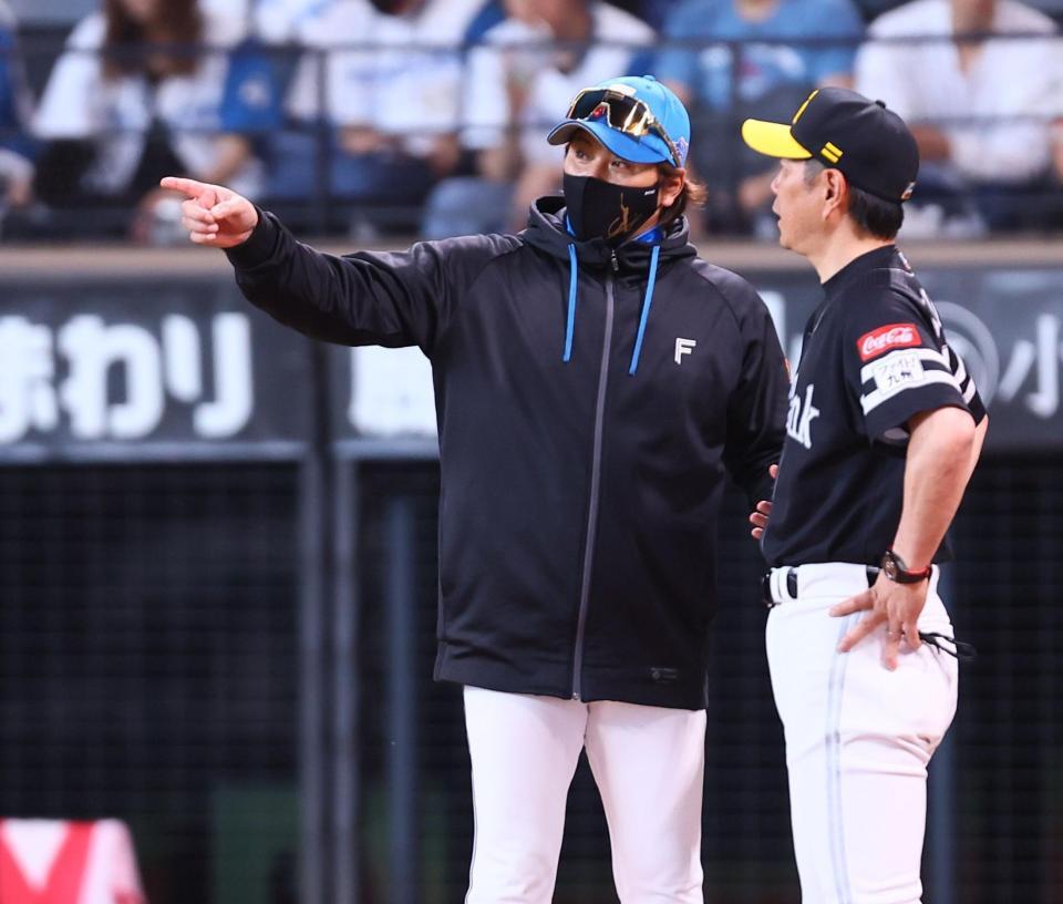 試合終了後、小久保監督（右）と話し込む新庄監督（撮影・中島達哉）