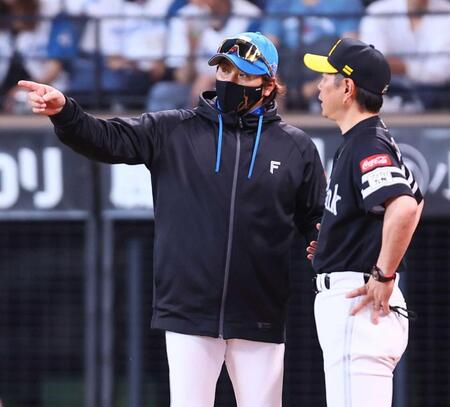 　試合終了後、小久保監督（右）と話し込む新庄監督（撮影・中島達哉）