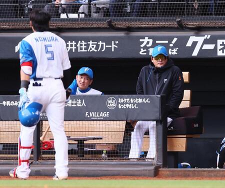 ４回、球場内に風が強く吹き込み、寒そうにグラウンドを見つめる新庄監督（左は空振り三振を喫し、ベンチに戻る野村）＝撮影・中島達哉