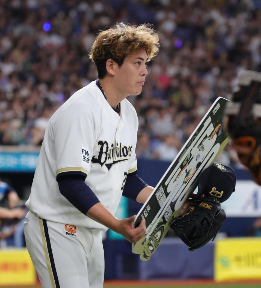 １５００投球回を達成し、ボードを手にファンの声援に応えるオリックス・九里亜蓮（撮影・坂部計介）