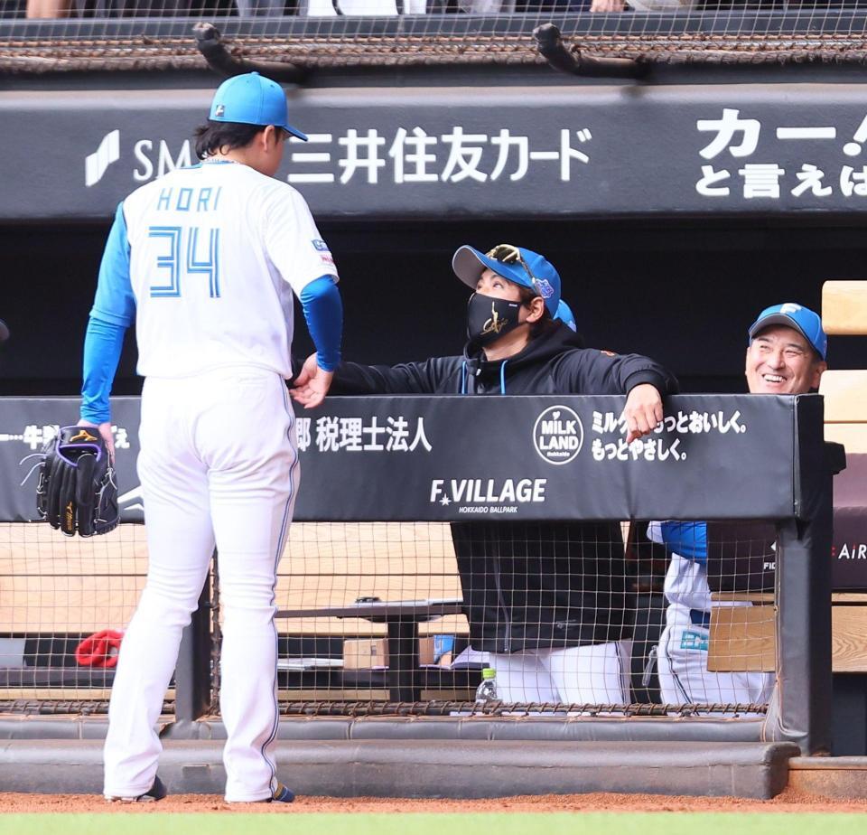 ３回途中から登板し、後続を抑えた堀（３４）に声を掛ける新庄監督（中央）＝撮影・中島達哉