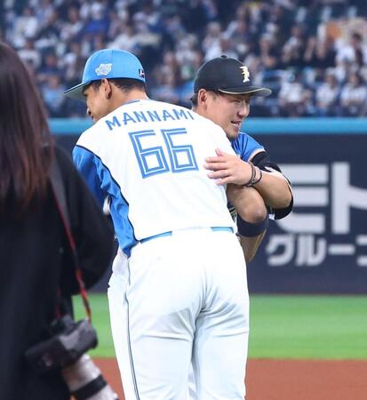 ファーストピッチセレモニーに登場し、万波（左）と抱き合う中田翔氏（撮影・中島達哉）