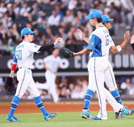 ９回、プロ初セーブの記念球を五十幡（左）から受け取る達（撮影・中島達哉）