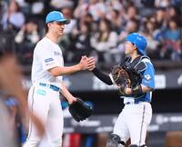 ９回を締めてプロ初セーブをあげ、田宮（右）とタッチを交わす達（撮影・中島達哉）