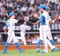 ９回、プロ初セーブの記念球を五十幡（左）から受け取る達（撮影・中島達哉）